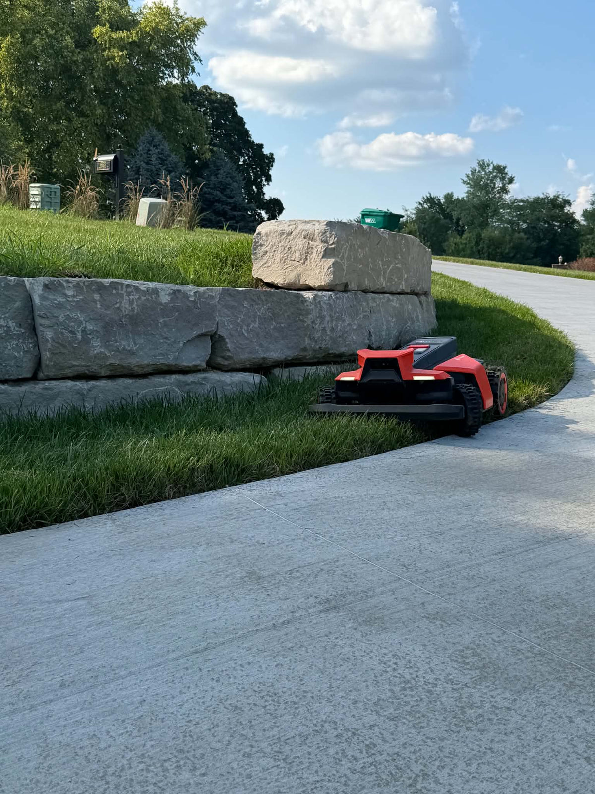 Segway Navimow X4 mowing along a stone wall